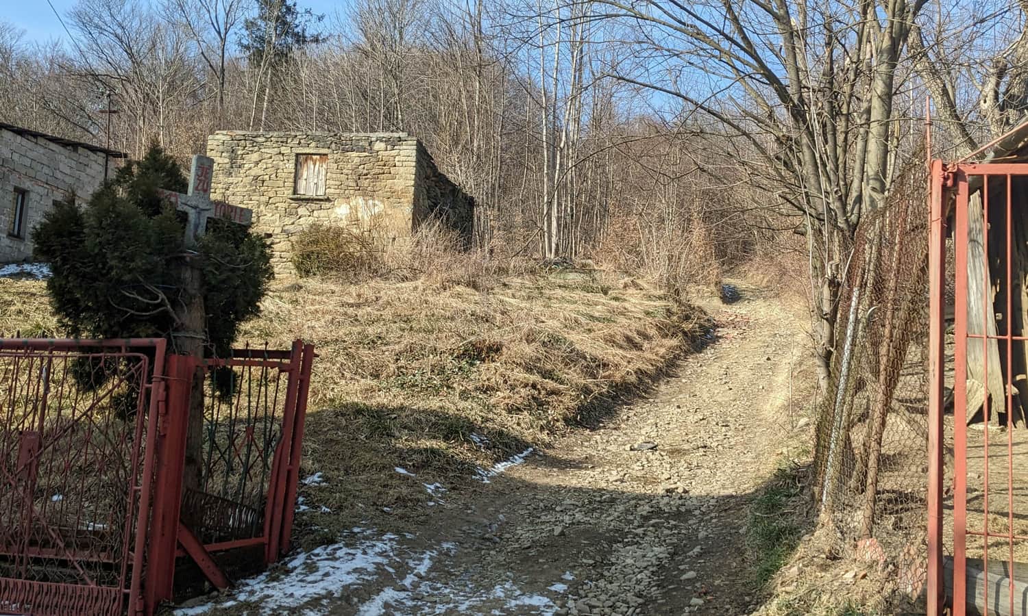 Tu niebieskie znaki skręcają z asfaltowej drogi w stronę lasu na Krowiej Górze.