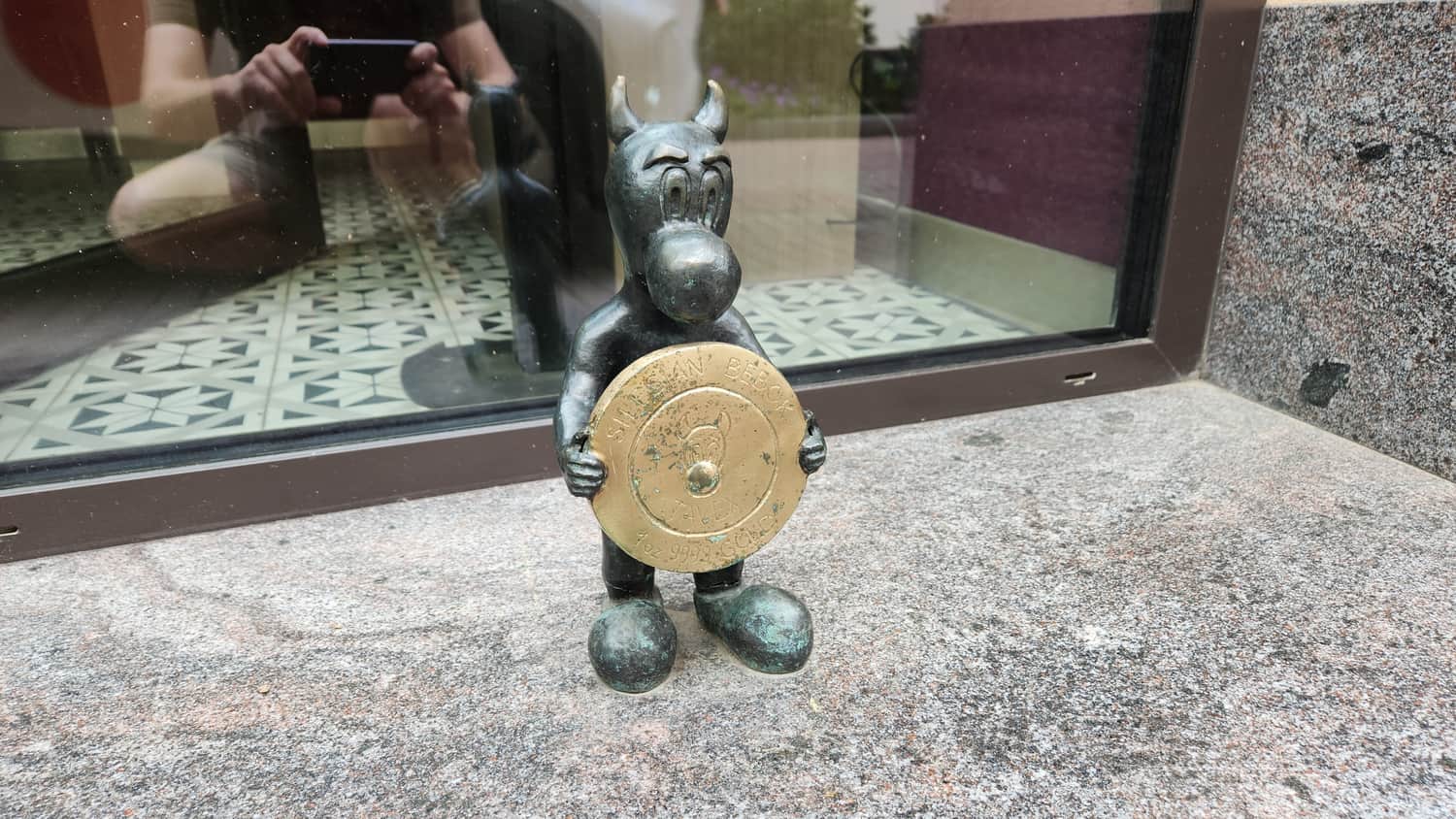 Uncjusz — a Bebok holding a gold coin, in front of a currency exchange on Wawelska Street