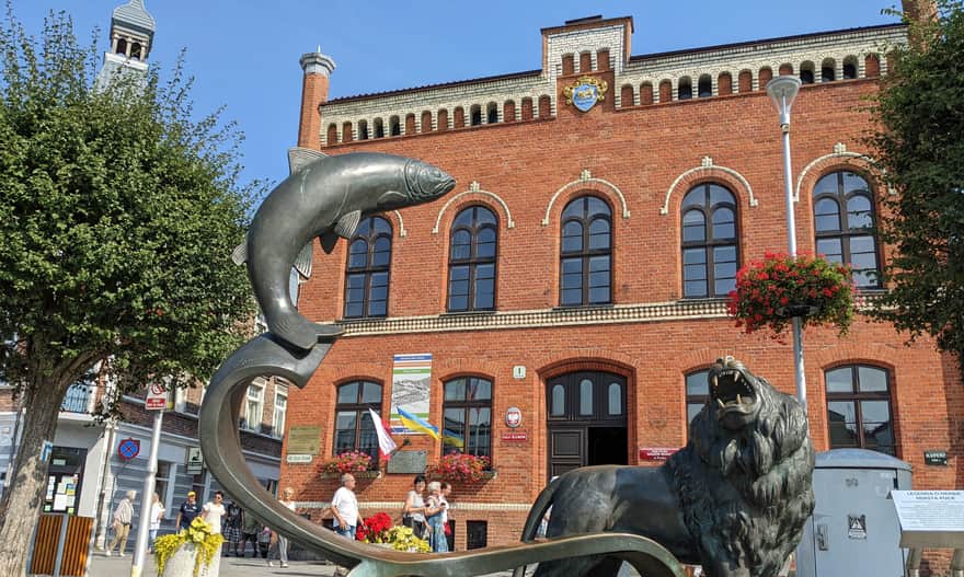 Ratusz w Pucku, pomnik lwa i łososia na rynku w Pucku