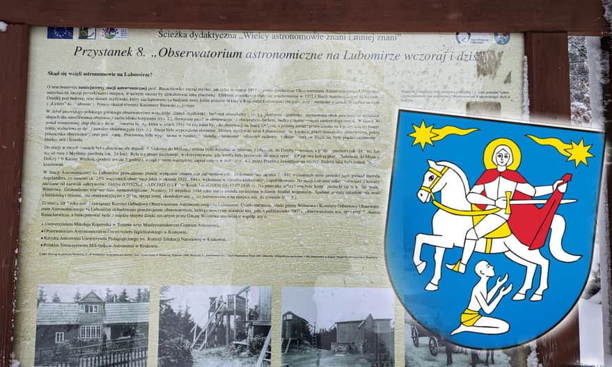 Information board describing the history of the astronomical observatory on the summit of Lubomir and the coat of arms of the Wiśniowa municipality