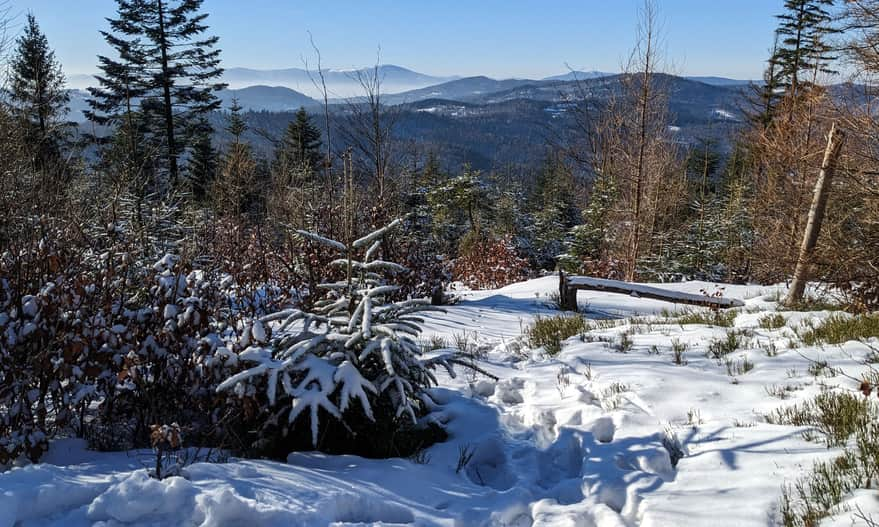 View window on the yellow trail Jawornica - Potrójna. View of Przełęcz Kocierska and Kocierz resort, Skrzyczne in the far background