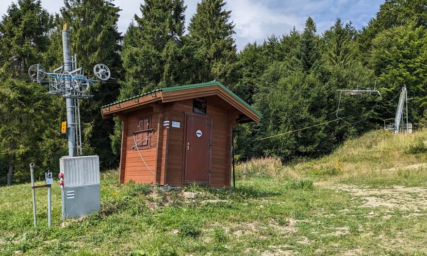 Uwaga: przy tej budce czerwony i zielony szlak wchodzą ze stoku w las!