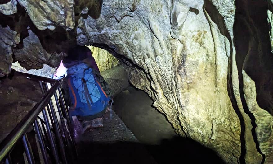 Jaskinia Mroźna - przejście "na czworakach" po metalowej kładce nad stojącą w niskim i wąskim korytarzu wodą
