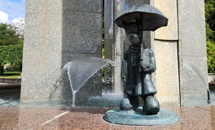 Doradziejka - Beboczka trzymająca w jednej rączce zbiór przepisów podatkowych, a w drugiej parasolkę, na fontannie przy pl. Grunwaldzkim